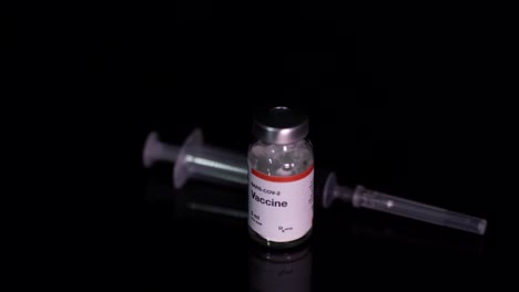 coronavirus vaccine bottle and syringe isolated on black background