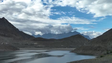 una hermosa vista del lago sadpara en skardu gilgit baltistan - un lago con montañas en el fondo y nubes sobre el cielo azul