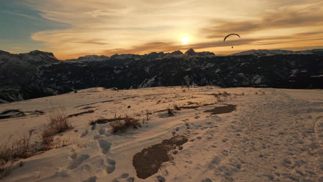 sunset paragliding over snowy mountain peaks
