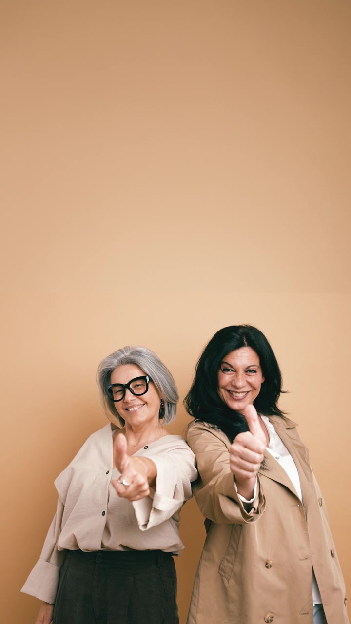 Two Mature Women Smiling and Giving Thumbs Up