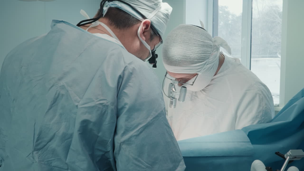 los cirujanos realizan cirugías complicadas. médicos experimentados en uniforme se involucran en el tratamiento de la enfermedad arterial operando al paciente en una sala de cirugía estéril.