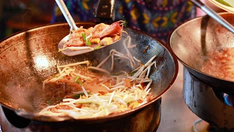 stir-frying pad thai at bangkok's floating market