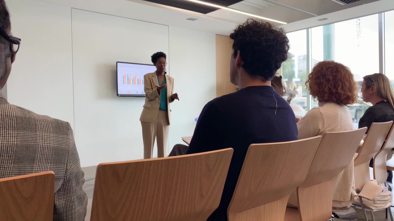 Businesswoman Giving a Presentation to Colleagues in a Modern Office