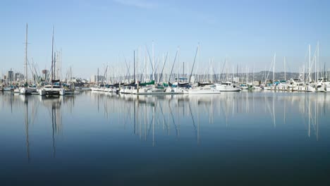 Eine-Saubere-Pfanne-Direkt-über-Glasklarem-Wasser,-Während-Die-Boote-In-Der-Sonnigen-Bucht-Glitzern