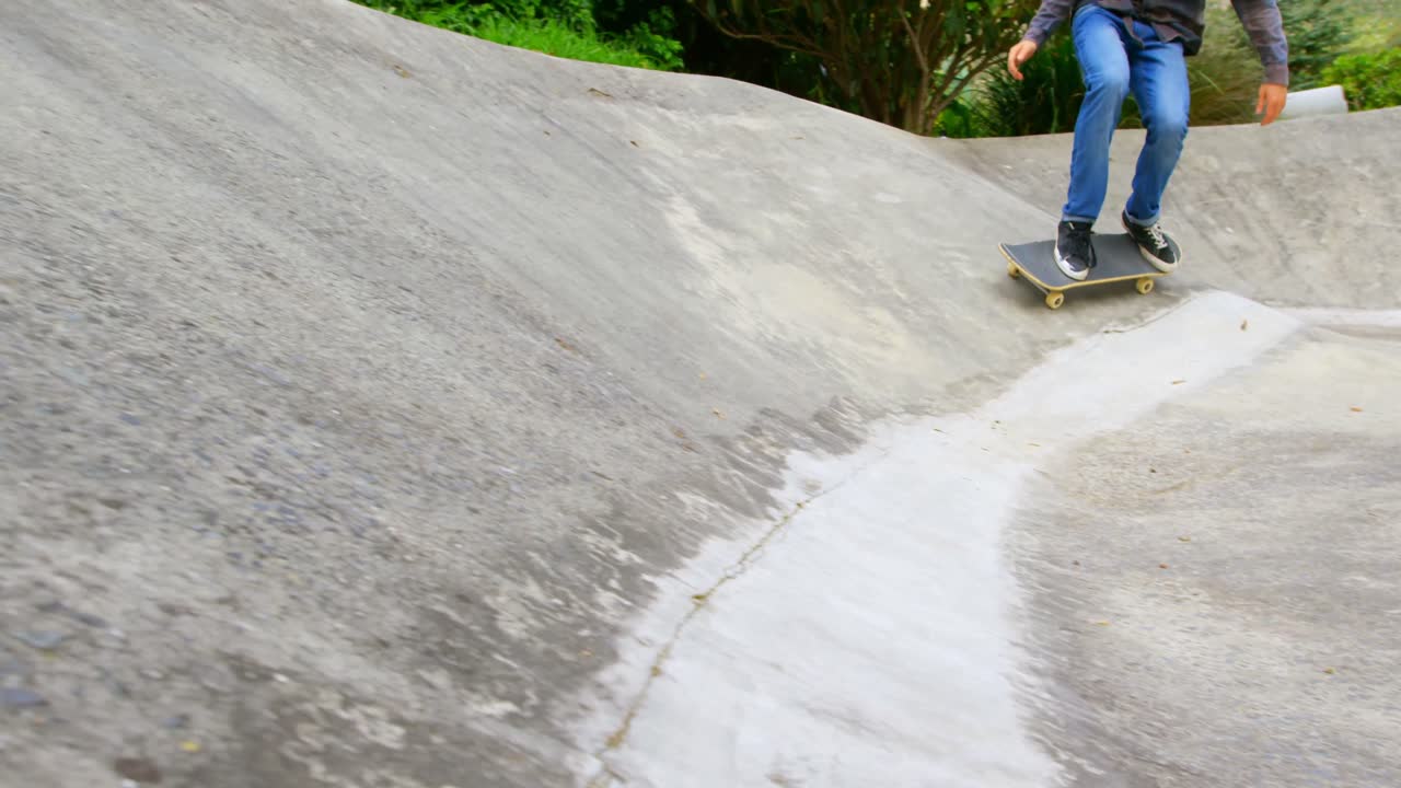 sección baja de un joven caucásico practicando patinaje en una rampa en un parque de patinaje 4k