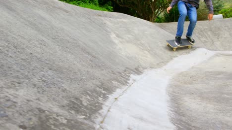 Low-section-of-young-caucasian-man-practicing-skateboarding-on-ramp-in-skateboard-park-4k