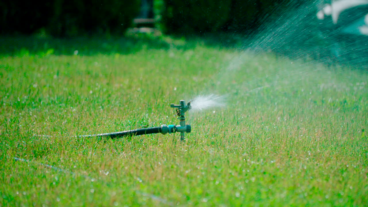 Close-up view of garden lawn sprinkler is watering grass, Grass watering with sprinkler irrigation system working