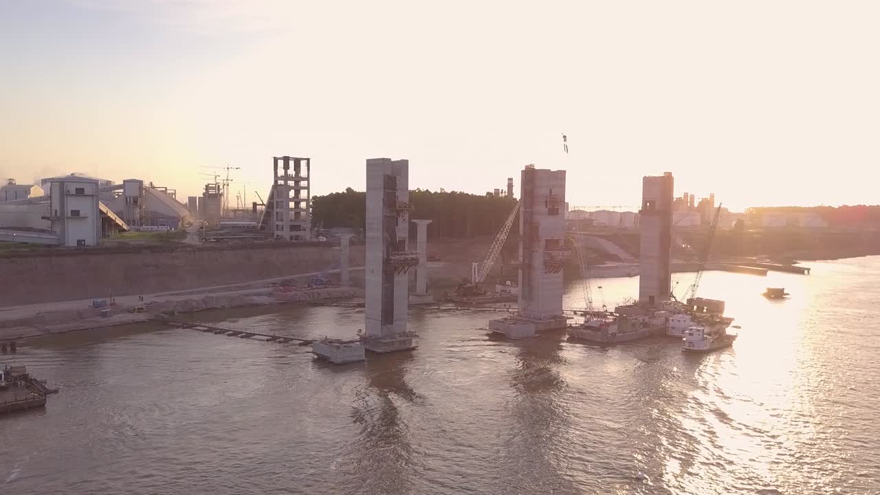 Aerial View of the Factory at the edge of the river carrying grains in a freighter whit the sunset