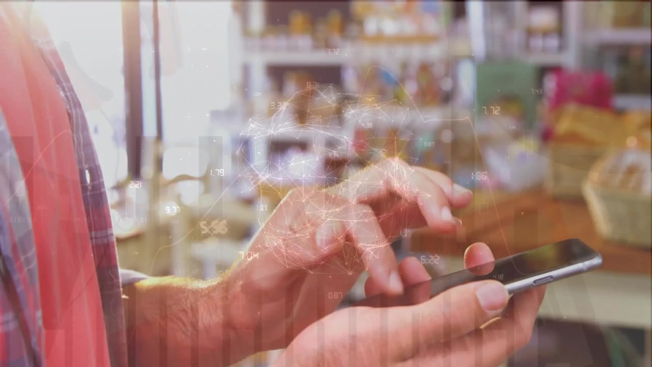Vídeo exibe dados financeiros em um globo com um homem ao telefone em um café.