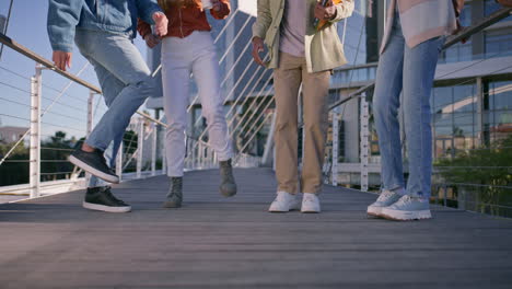 group of stylish young people walking on a bridge