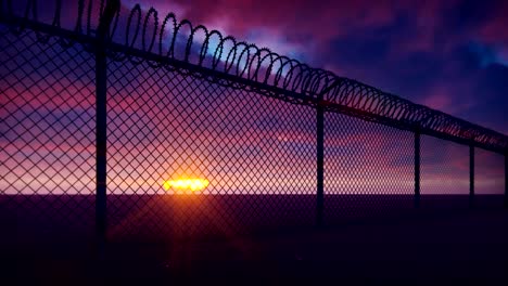 through a metal prison fence with barbed wire visible clouds and a disturbing sunset. loops realistic 3d animation.