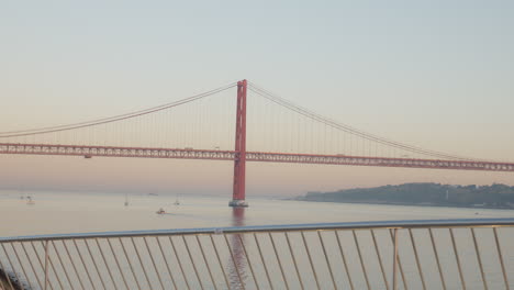 runner rests against railing with a bridge in the background, medium shot