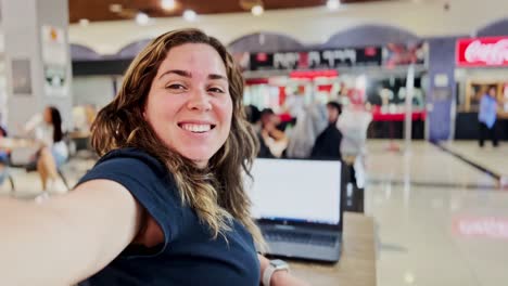 woman telecommuting from a bright public cafeteria