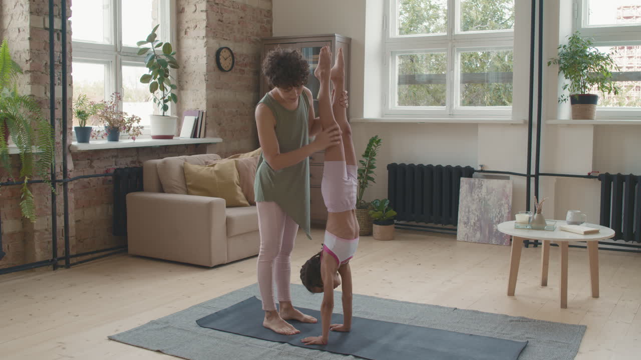 niño practicando handstand con el instructor en casa