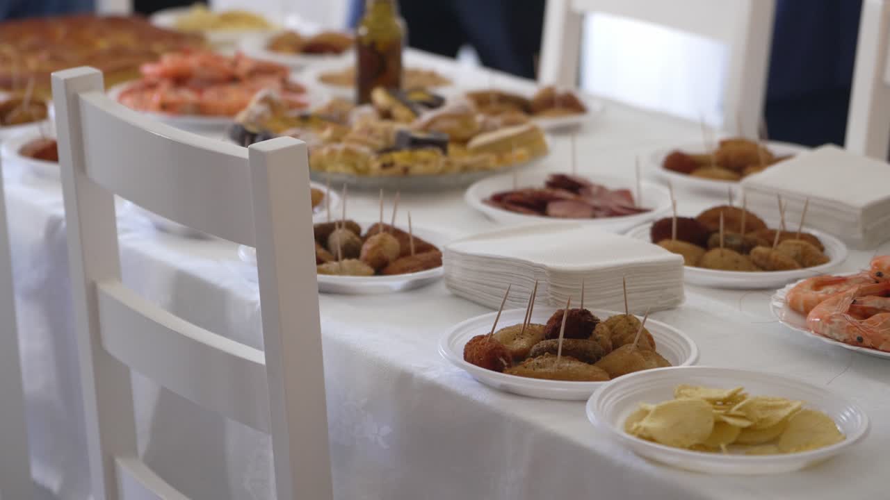 Close up of a buffet table featuring assorted appetizers, finger foods, and neatly stacked napkins