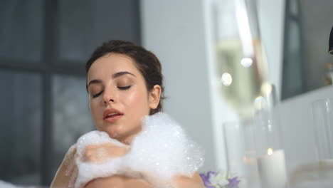 mujer caucásica relajándose en un baño con espuma
