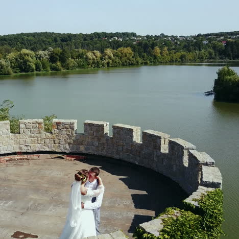beautiful romantic wedding couple of newlyweds hugging in an old castle. aerial view square video