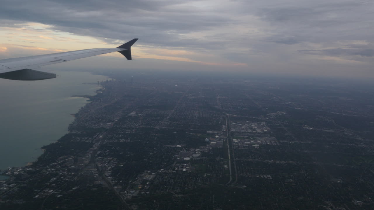 Aerial view of Chicago Illinois over Downtown and Lake Michigan out of plane window 4k