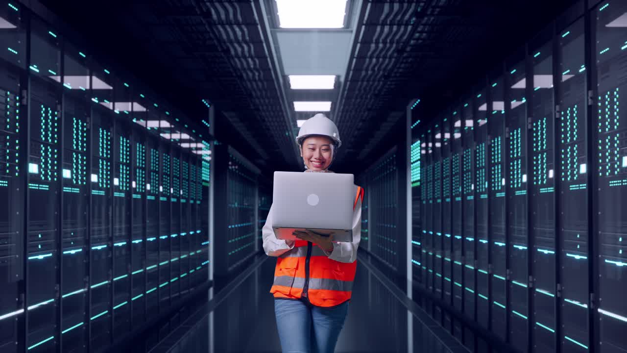 Front View of Asian Female Engineer Use Computer While Walking in Server Room Data Center