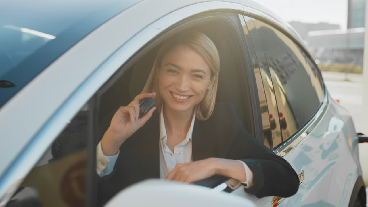 женщина заряжает электромобиль на зарядной станции