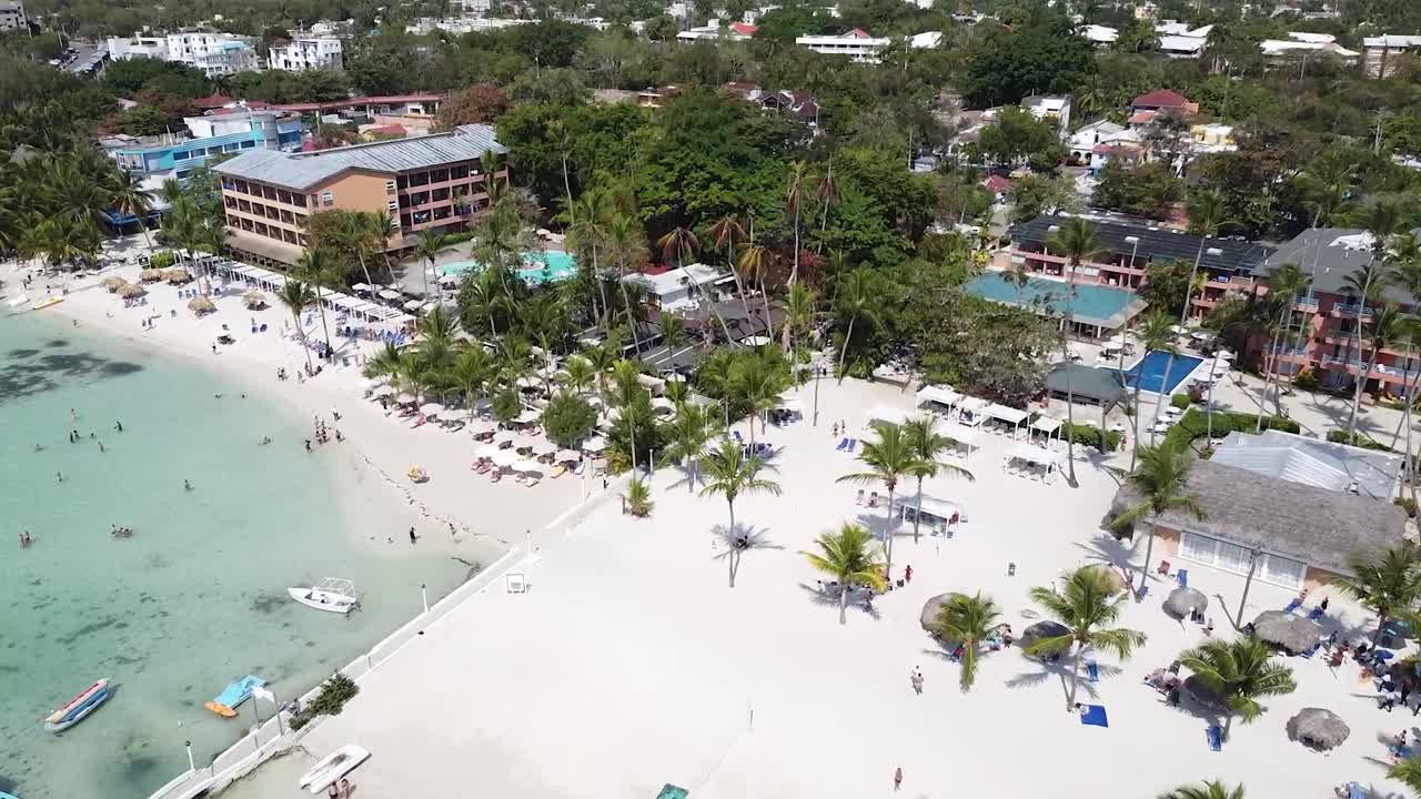 tiro de drones acercándose a la hermosa playa tropical de boca chica en república dominicana, día soleado con hermosos barcos en el puerto deportivo