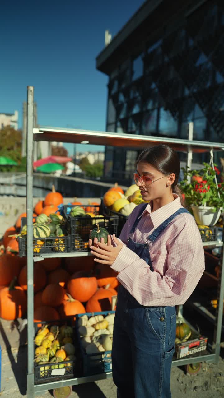 mujer comprando calabazas en un mercado de otoño