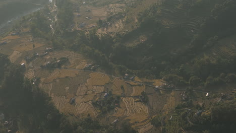 drone shot of a nepali village showcasing terrace farming, rivers, forests, and housing captures a beautiful view of traditional agriculture and the stunning natural landscape