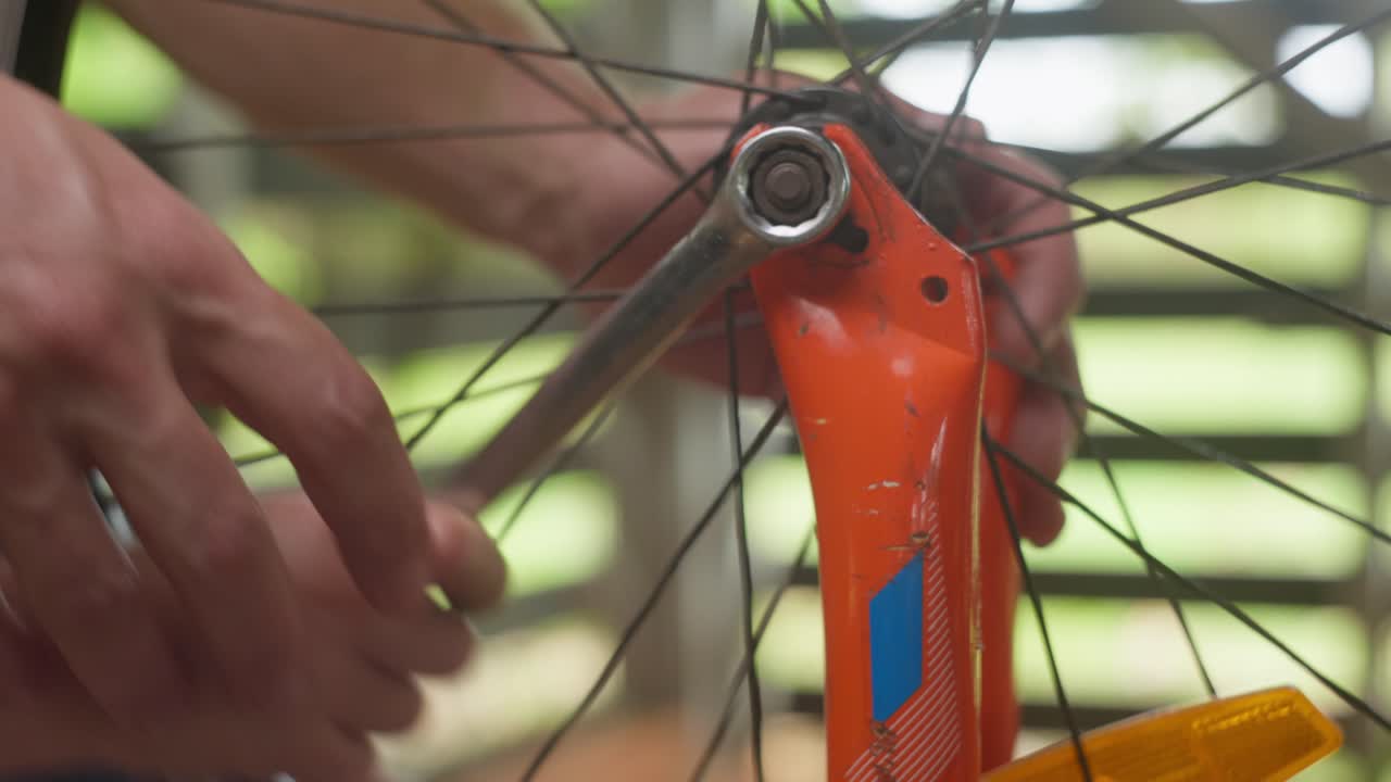 Man and his son working together, Dad is teaching his son about tools and fixing his bicycle. Clip 4