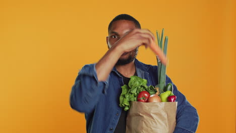 joven feliz anunciando frutas y verduras orgánicas cultivadas localmente