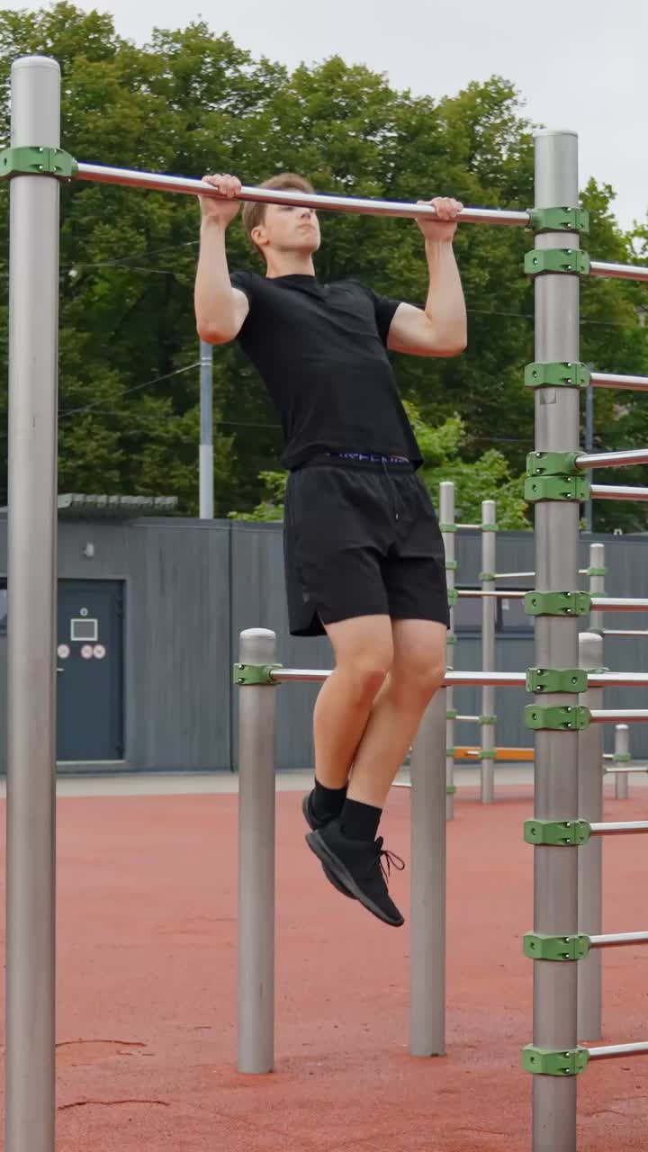 Young Man Exercising Outdoors On Monkey Bars - Vertical Shot