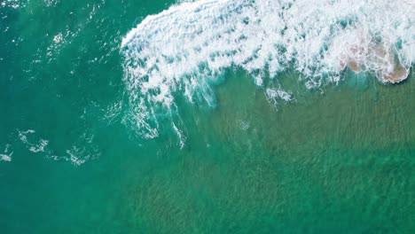 bright green blue ocean topview of waves washing upon shore from ocean sea waters