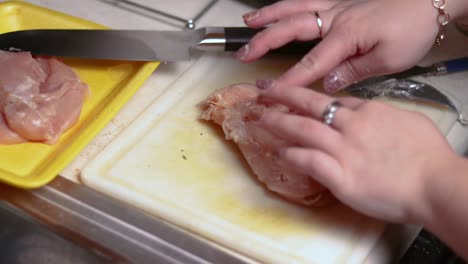 usando palillos para asegurarse de que la pechuga de pollo rellena no se abra durante la cocción