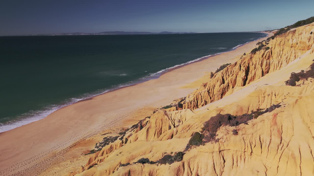 volando sobre formaciones rocosas en la orilla de la playa de gale en el algarve, portugal