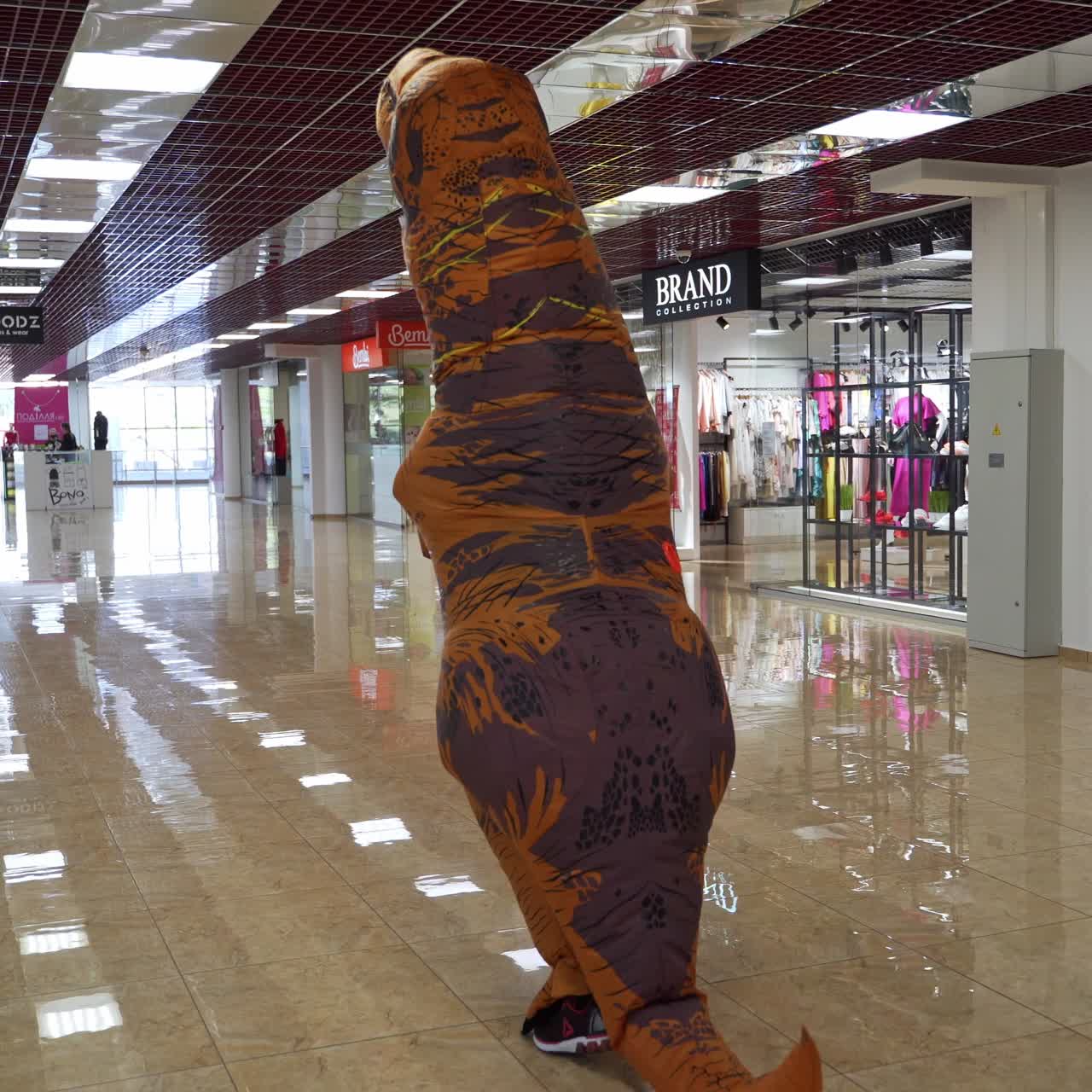 Rex costume walking and shopping. Person in dino costume in mall