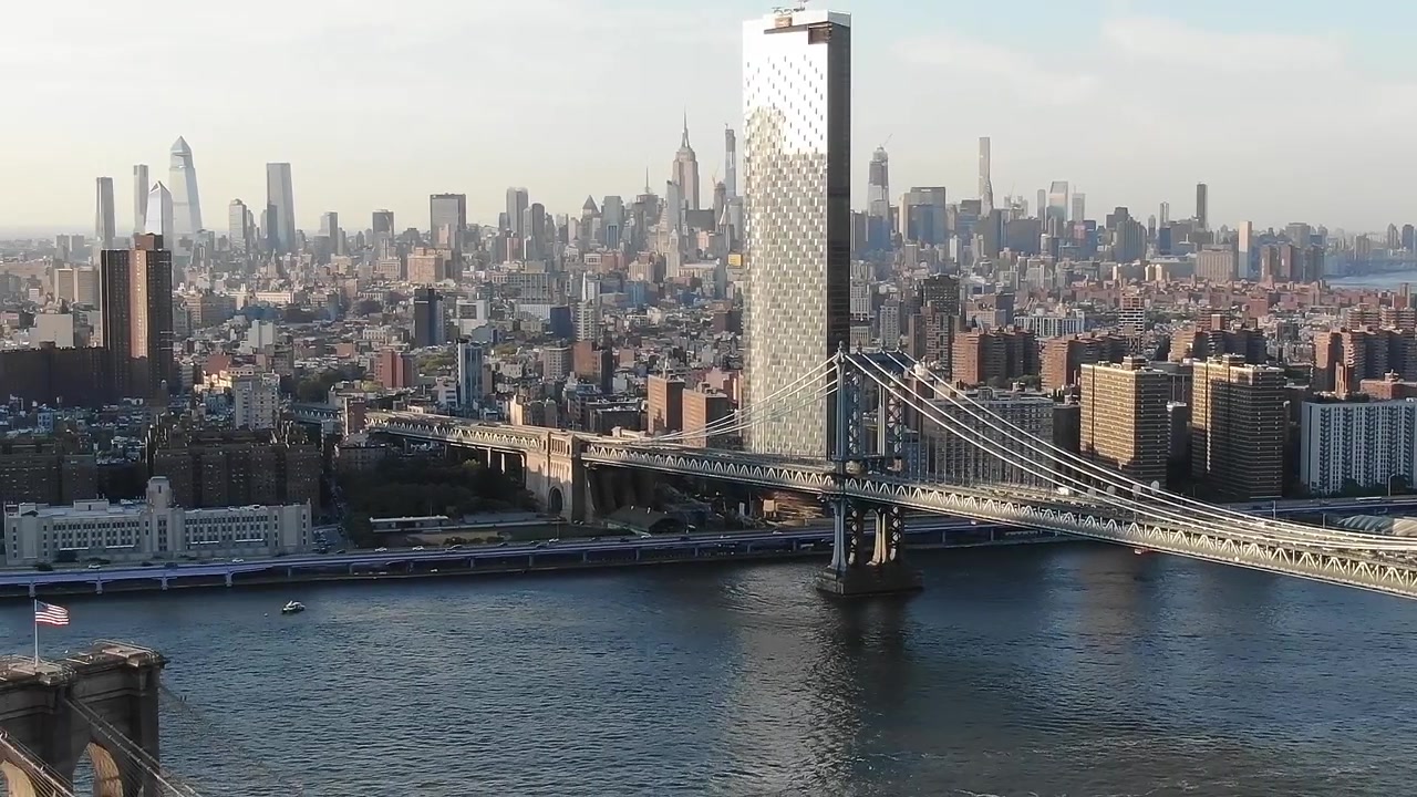 Vue de la skyline de New York avec un pont sur l'eau au coucher du soleil