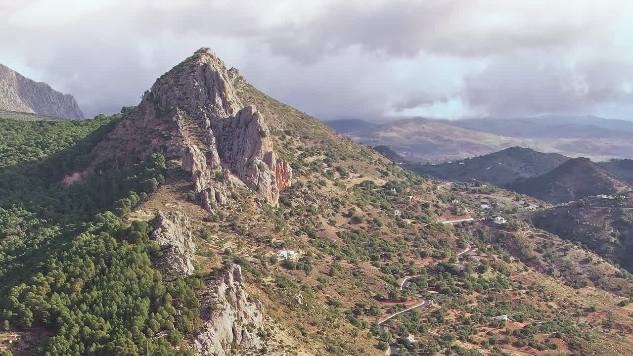 Vista delle colline rocciose di Malaga con cielo nuvoloso e strada tortuosa