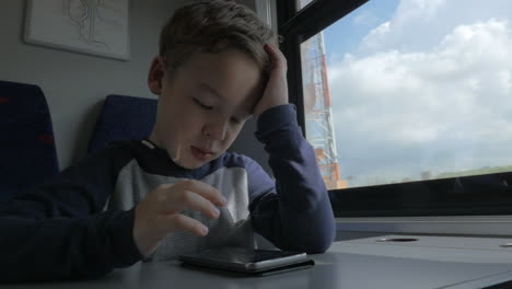 bored kid with with cellphone in moving train