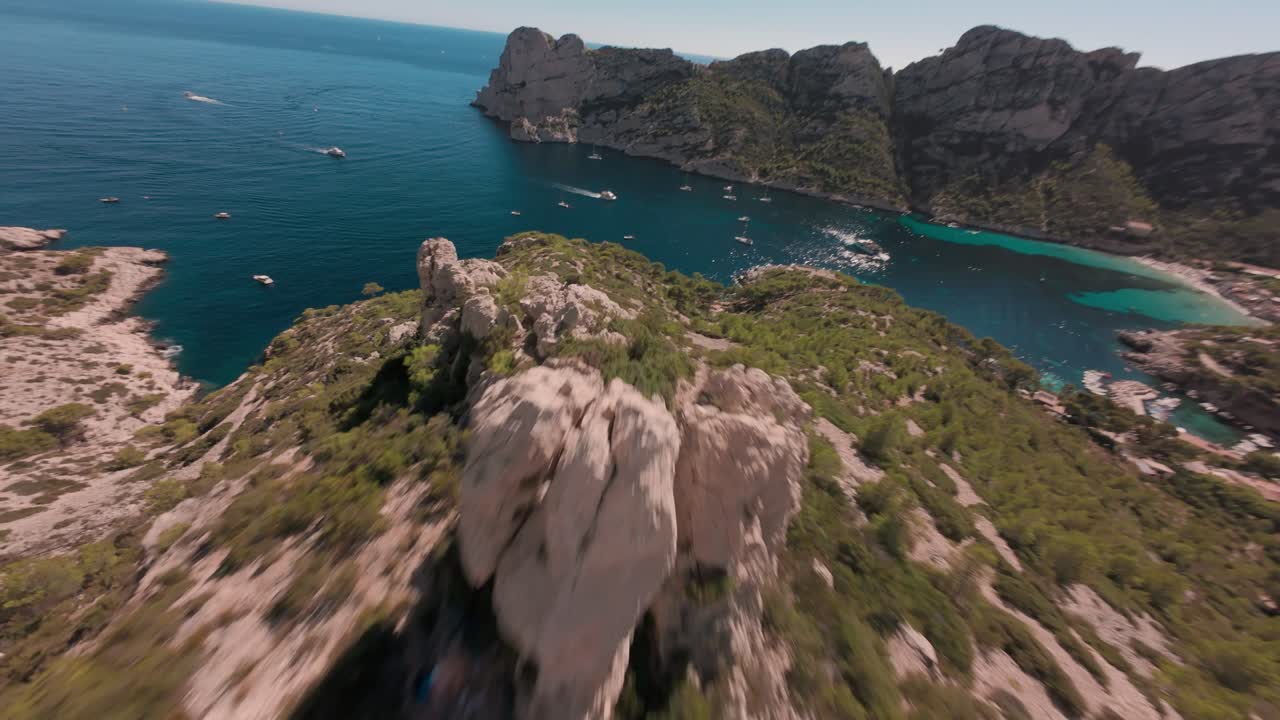 Ripresa dinamica con drone FPV che vola velocemente giù da una montagna verso l'oceano vicino a Montpellier, nel sud della Francia, mostrando un drammatico paesaggio costiero e uno scenario mediterraneo