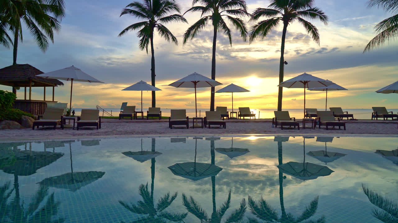 Paraply og stol omkring swimmingpool i resort hotel til fritidsrejser og ferie nær havet strand ved solnedgang eller solopgang tid