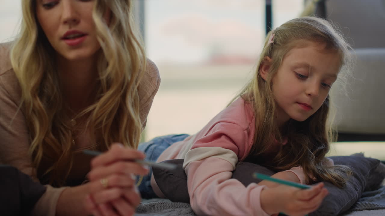 Mom teaching daughter how to paint at home. Mother spending time with kids.