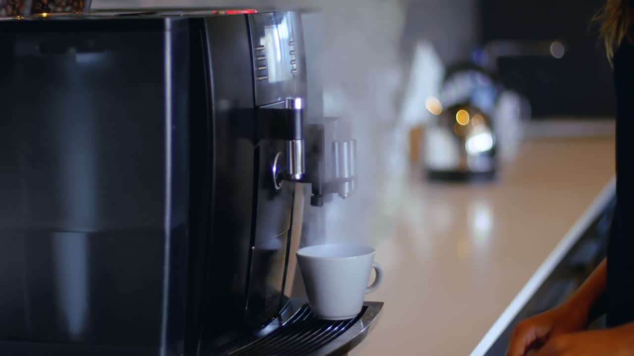 mujer ejecutiva preparando café en la cafetería de la oficina 4k