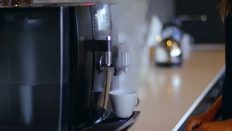 mujer ejecutiva preparando café en la cafetería de la oficina 4k