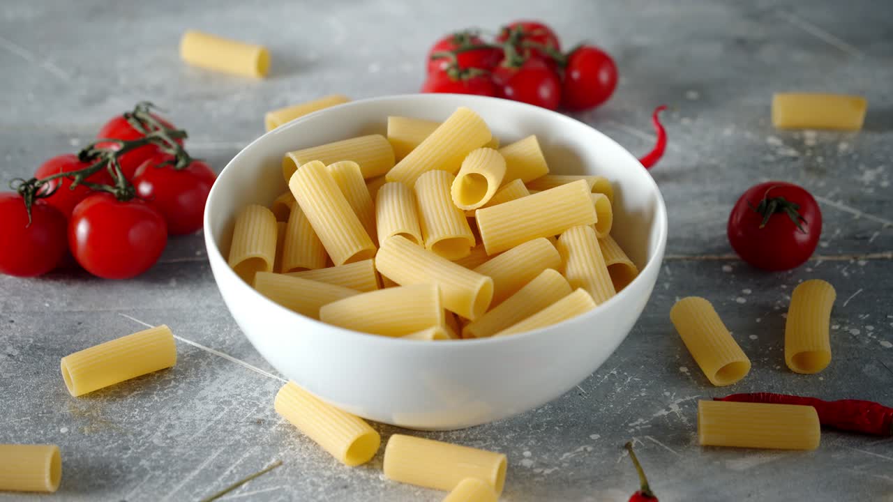 la pasta de cannelloni seca en un cuenco con tomates gira lentamente.