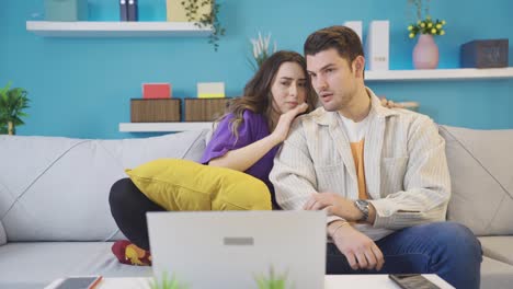 una joven pareja enamorada viendo películas de terror y thriller en casa, están asustados.