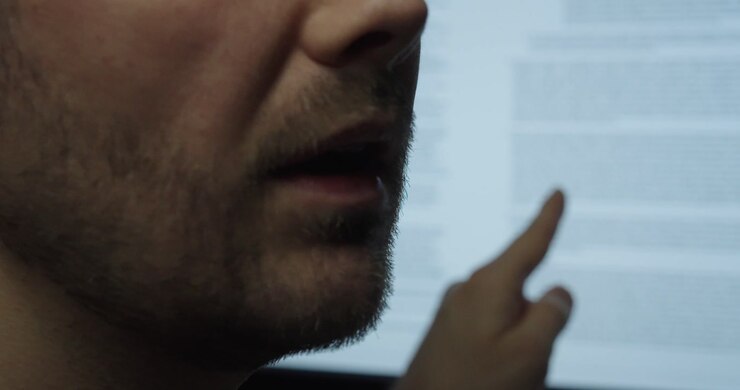 Close-up of a man explaining contract terms while pointing at a document on screen. Concept of agreement, legal review and business communication.