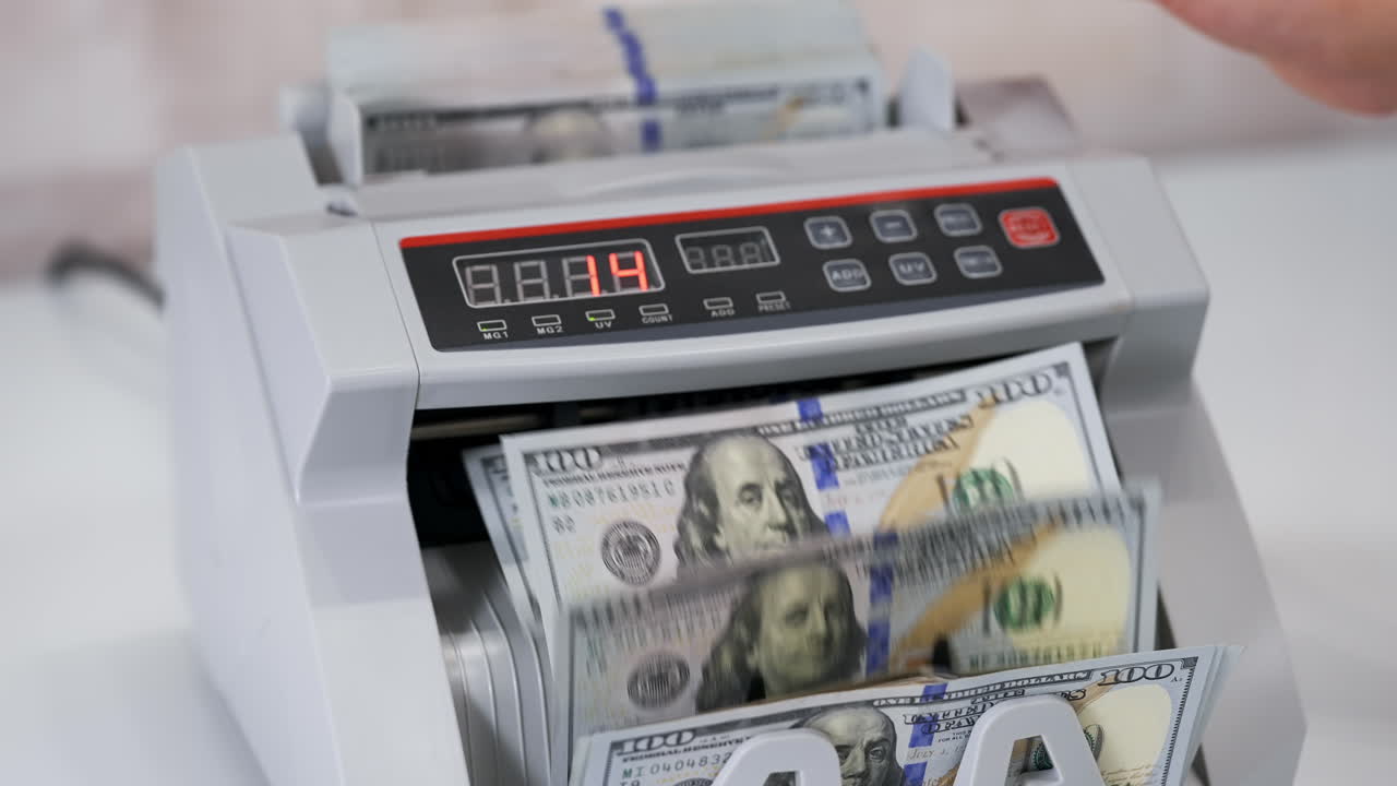 Money counting equipment for paper money calculation. Automatic mechanism for bank financial operations. Currency exchange of one hundred usd. Closeup currency counting machine counting dollar bills