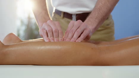paciente femenina recibiendo masaje de piernas de un fisioterapeuta masculino
