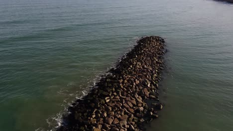 Aerial-flyover-outstanding-rocky-island-with-resting-birds-on-the-Atlantic-Ocean,Argentina