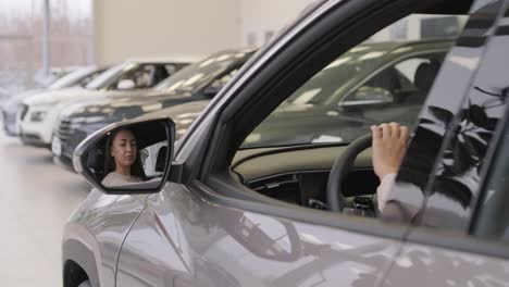 woman choosing a car in a car showroom