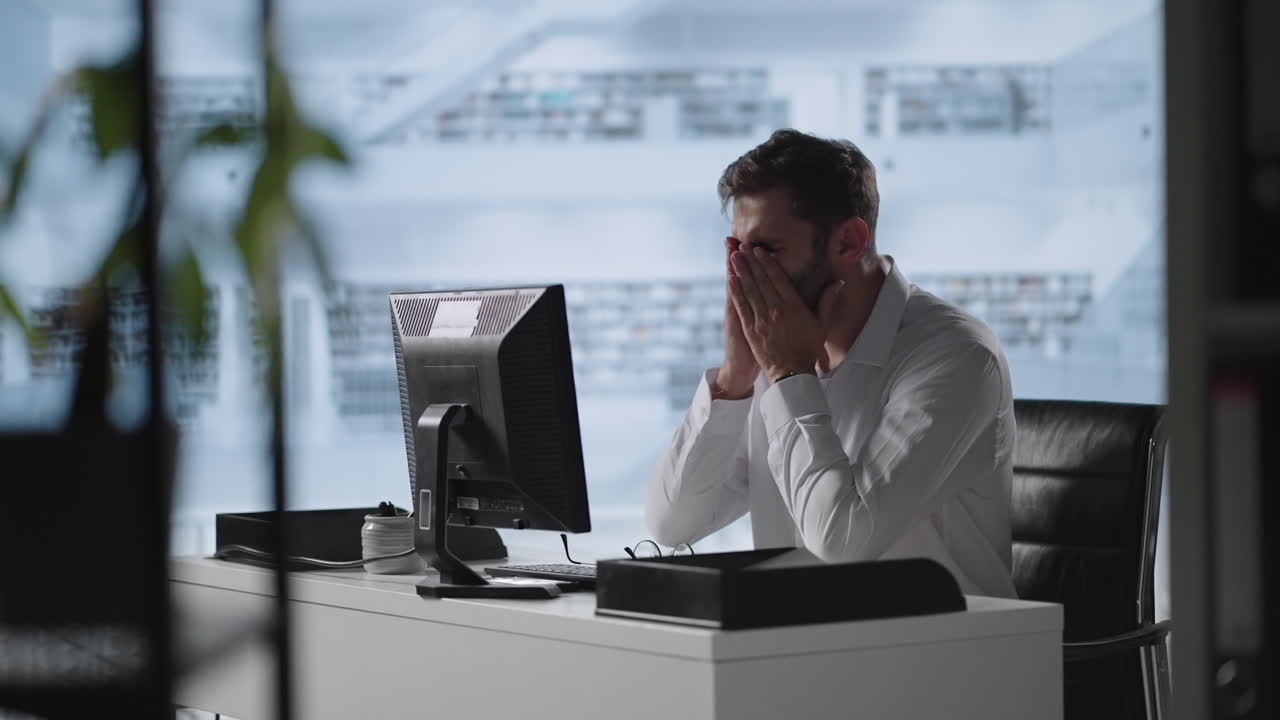Exhausted man taking off glasses feeling eye strain from computer. Stressed overworked businessman taking off glasses tired from computer.